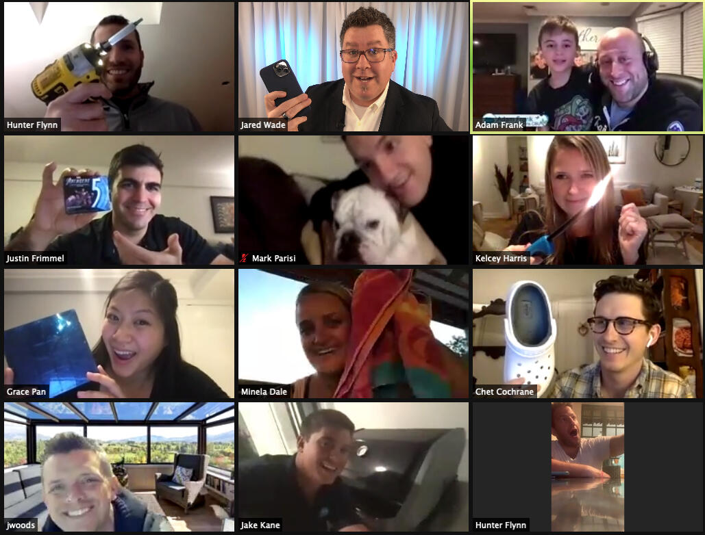 Zoom gallery of twelve participants holding up quirky items and smiling during a virtual game.
